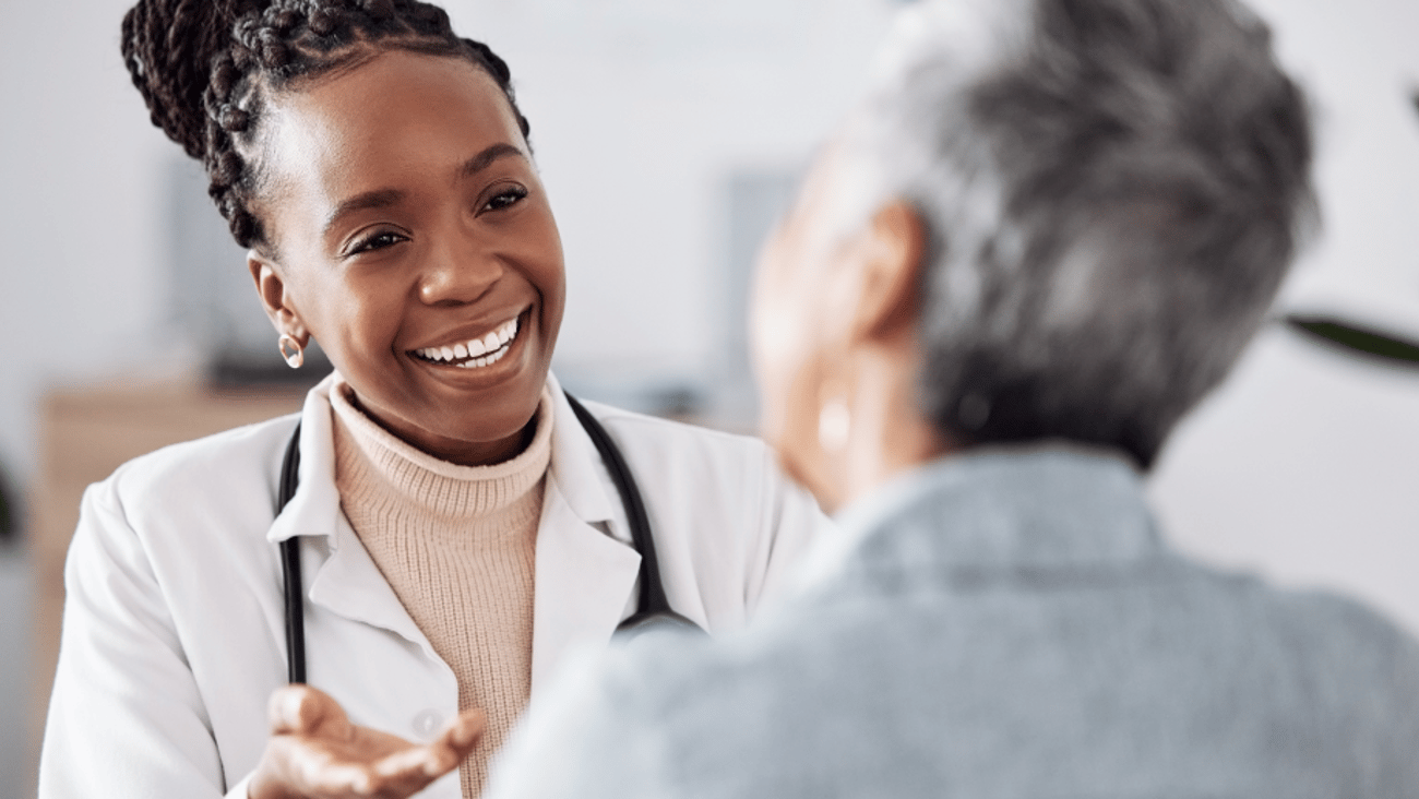 Smiling doctor talks to a patient in an office.