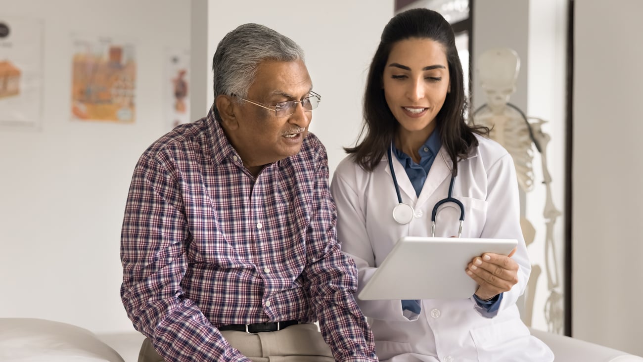 Young doctors showing a tablet screen to an older patient