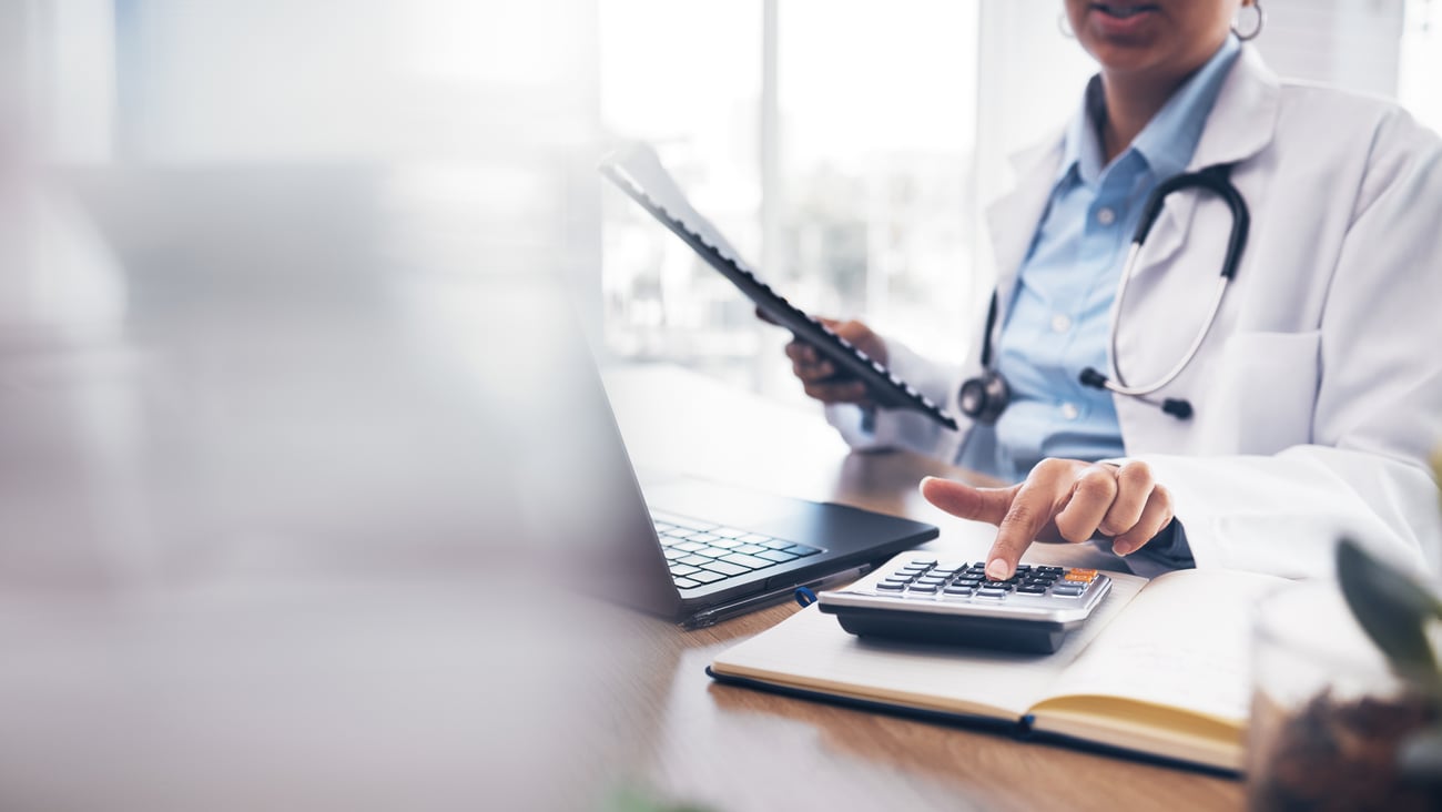 Physician at a computer making calculations 