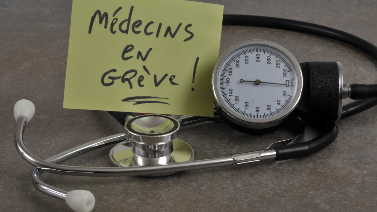 A stethoscope with a note that says "Doctors on strike" in French.