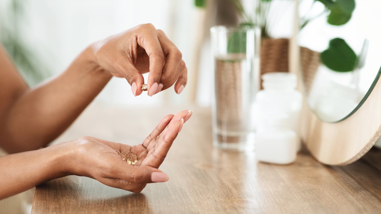 hands taking gel vitamins