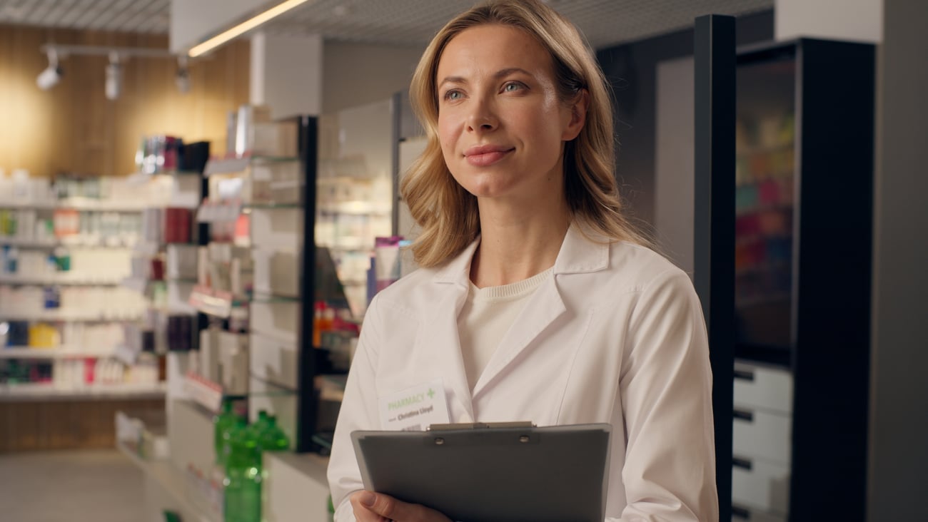 Young white woman pharmacist looking proudly out into the establishment