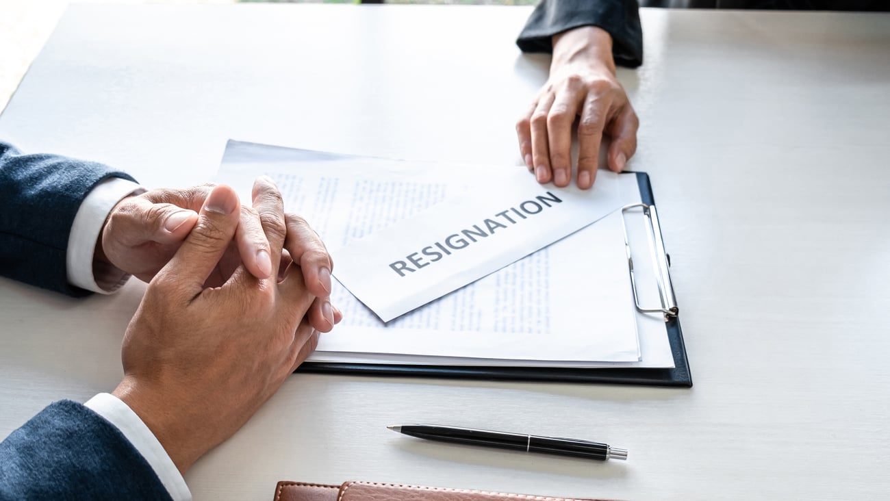 A hand sliding over a resignation letter