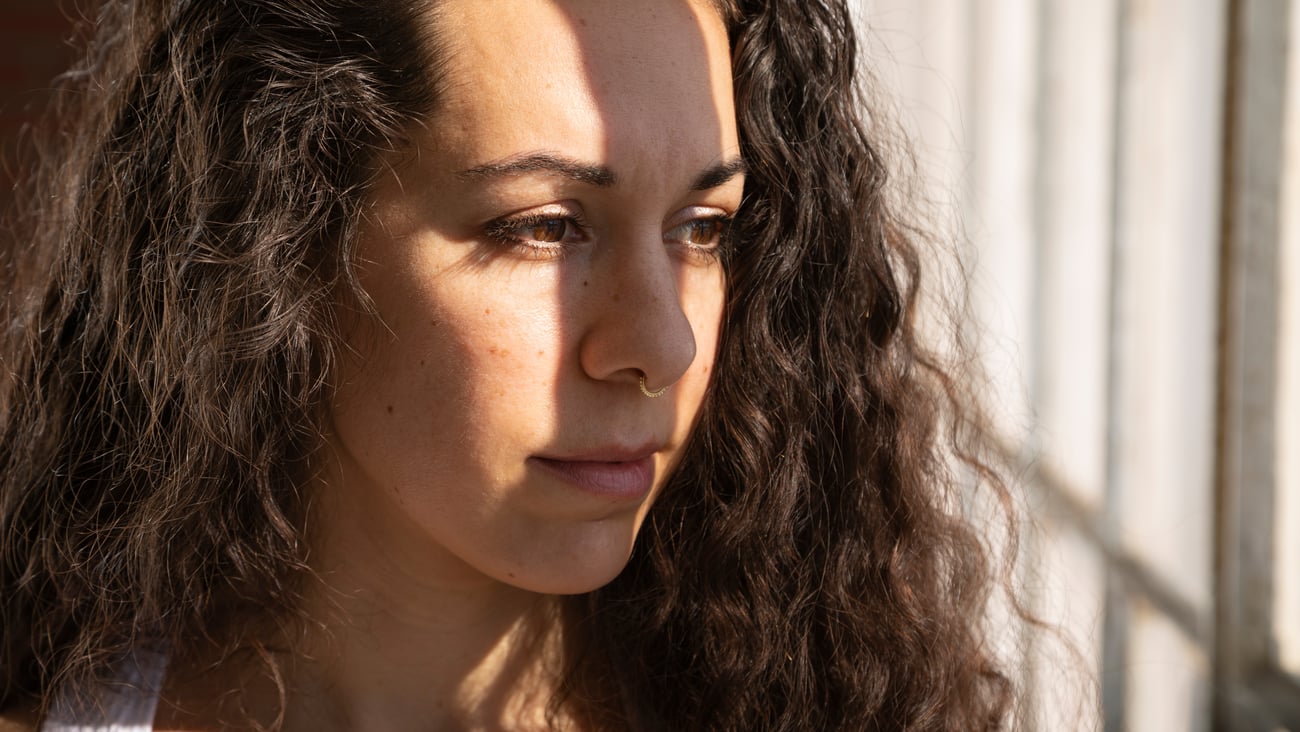 Young healthy woman with curly brown hair and a nose ring
