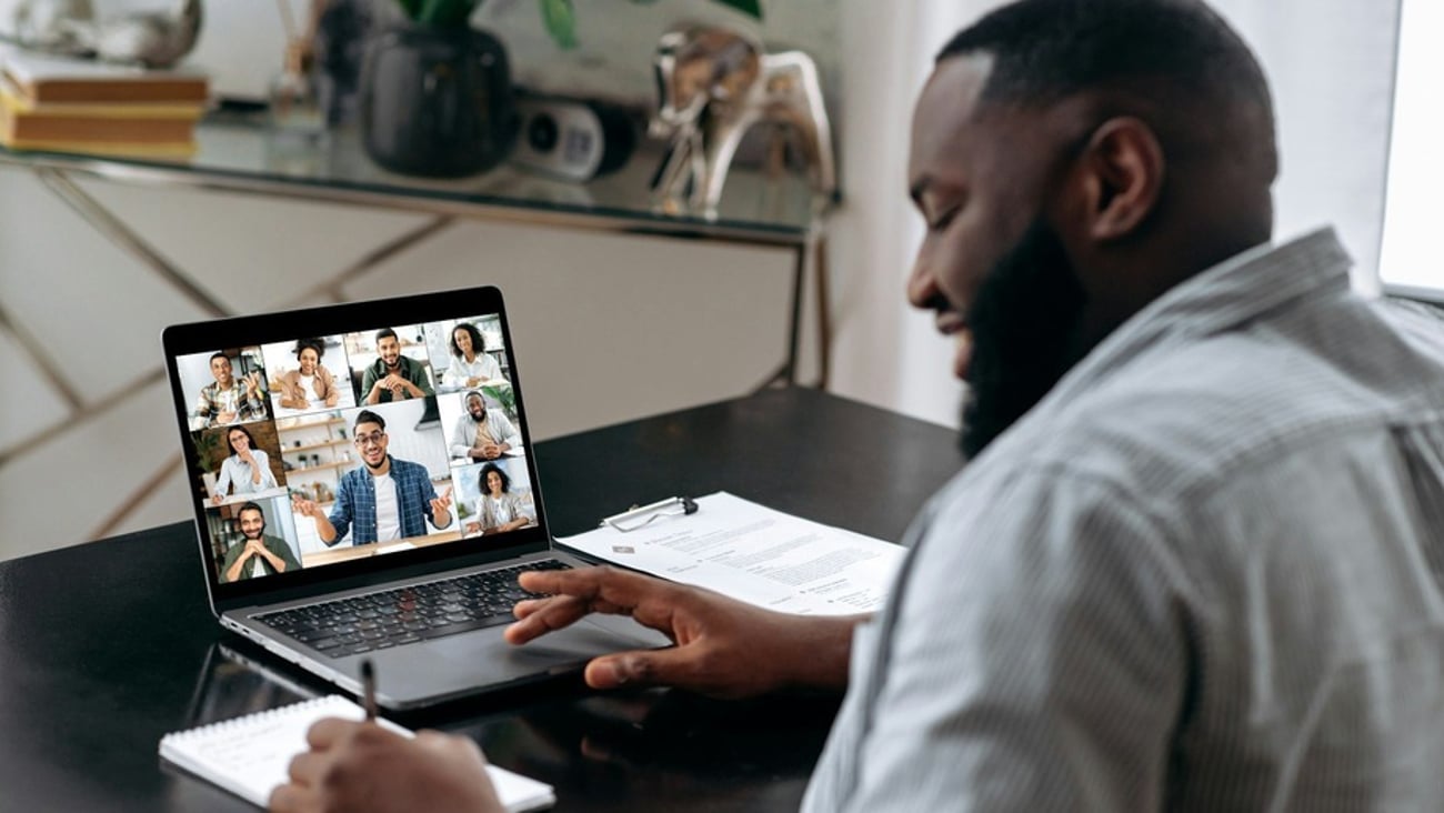 Man attending virtual meeting on laptop.