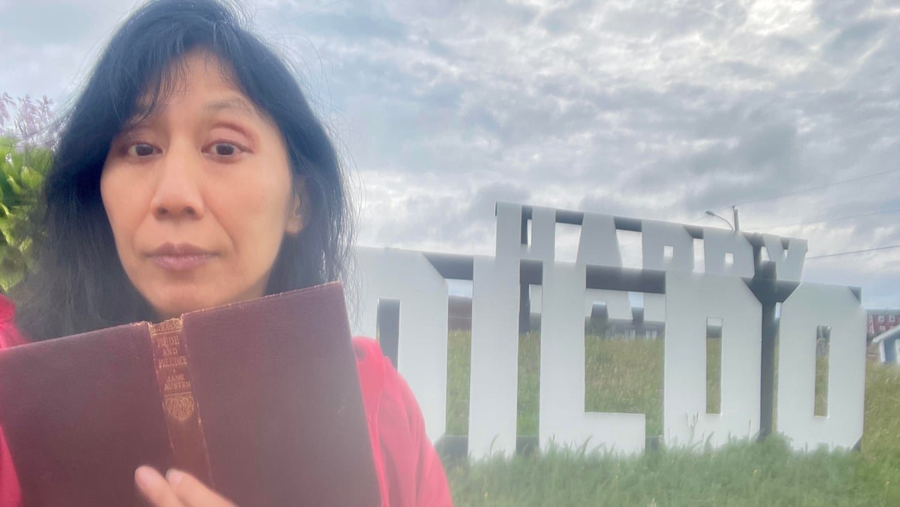 Dr. Melissa Yuan-Innes in front of a sign on Dildo, NL