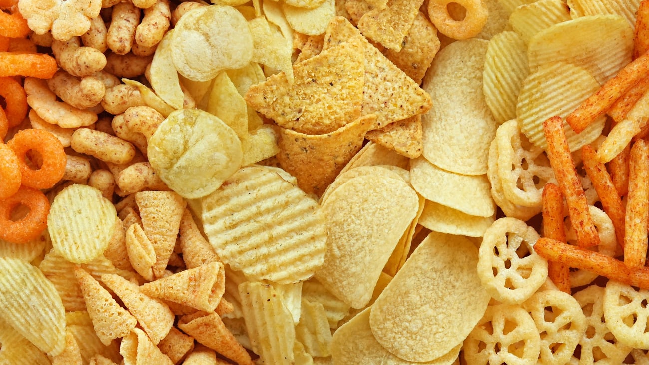 Colourful mix of salty snacks for beer varieties: chips and pretzels, onion rings and crackers. 