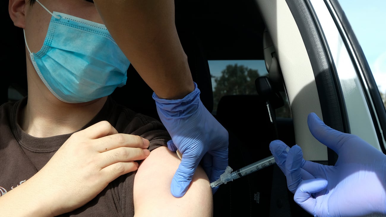 A medical staff gives a drive-thru attendee an influenza vaccine during a drive-thru free flu shots in Los Angeles on Nov. 20, 2020.