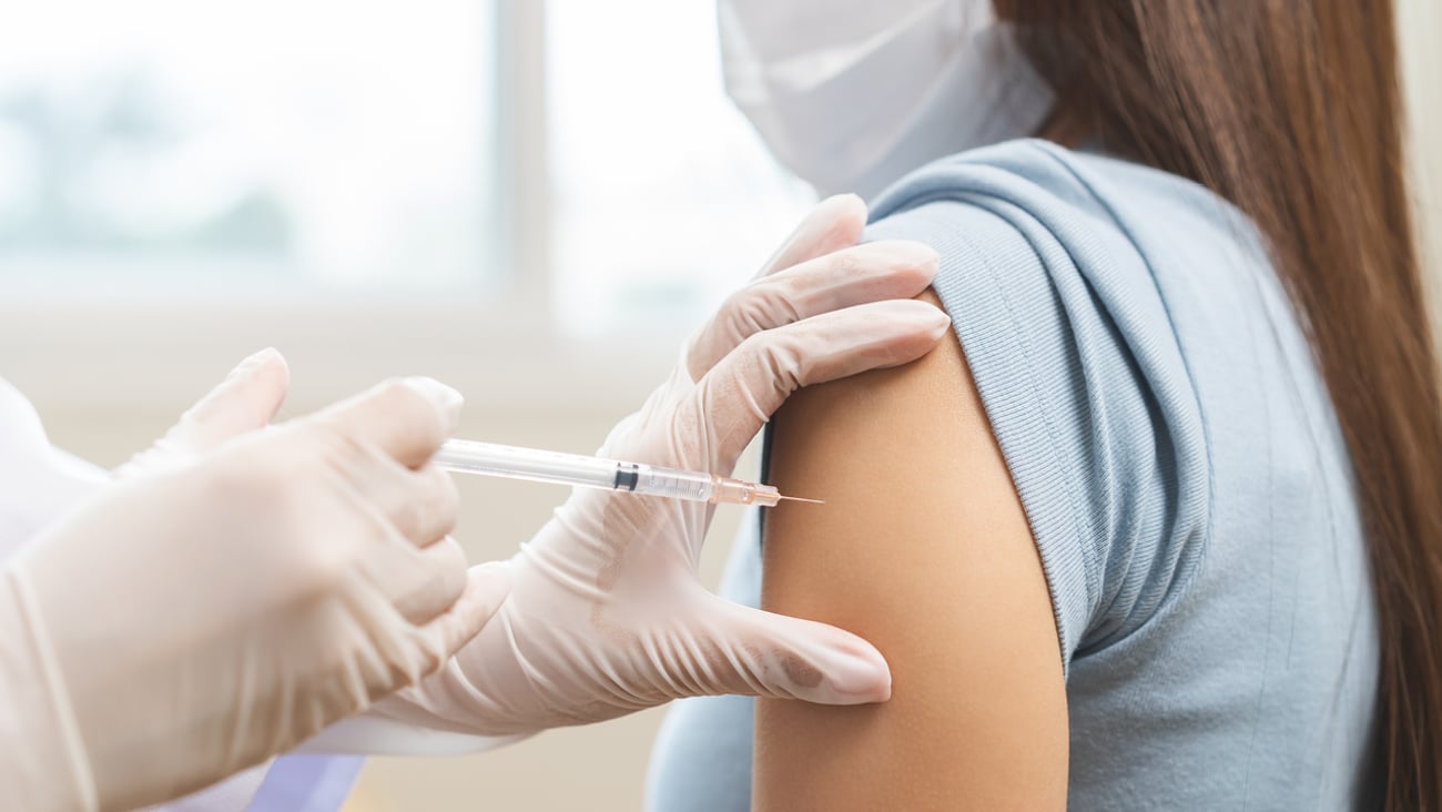 Young woman receiving a vaccination in her left shoulder