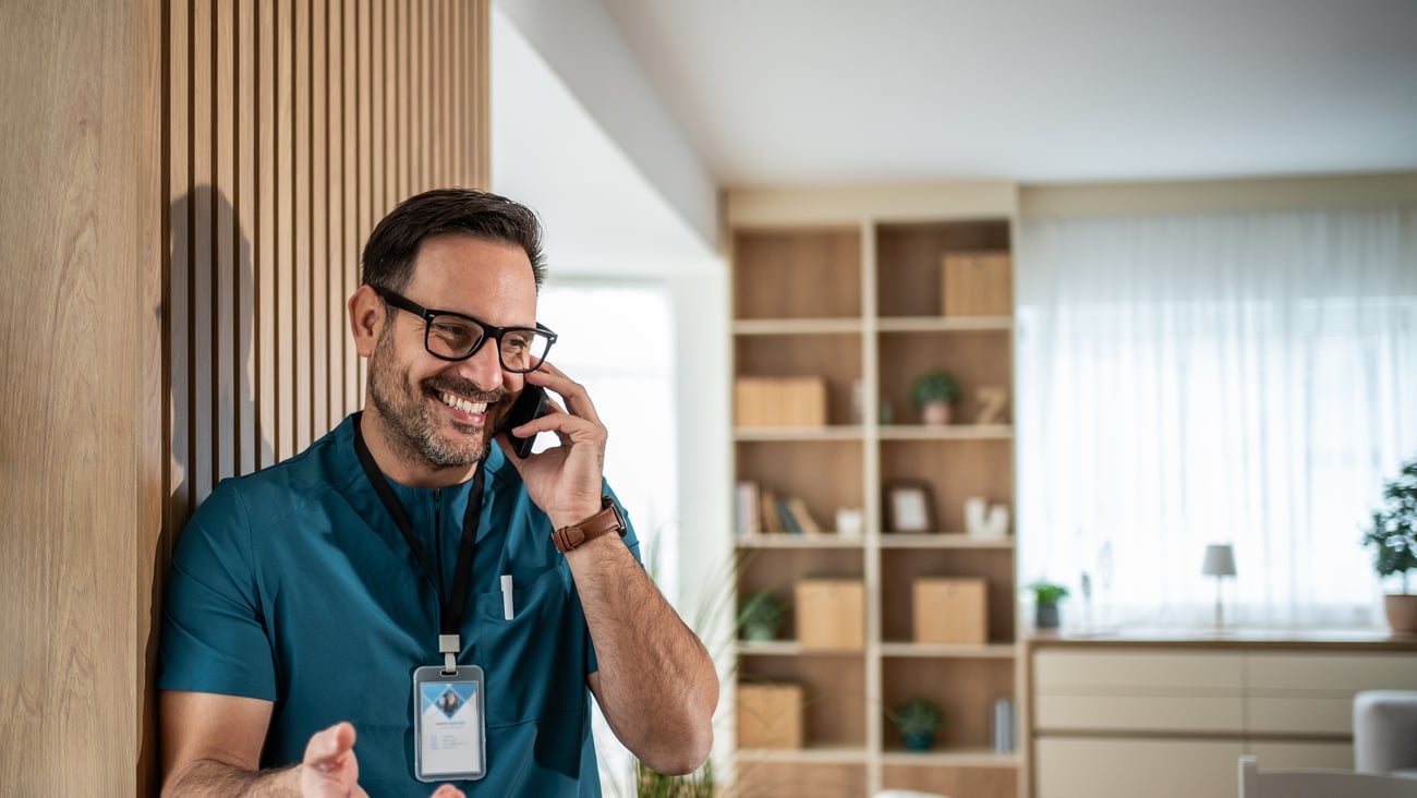 Young male physician chatting on the phone with a patient