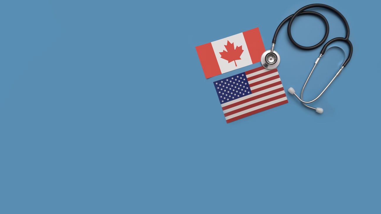 Flags of Canada and the U.S. next to a stethoscope.