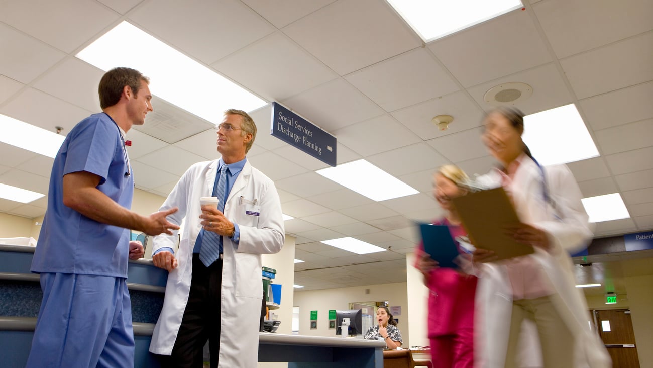 Two doctors talking in a hospital waiting area.