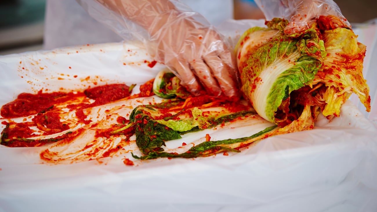 Close up of a cook's hand preparing kimchi