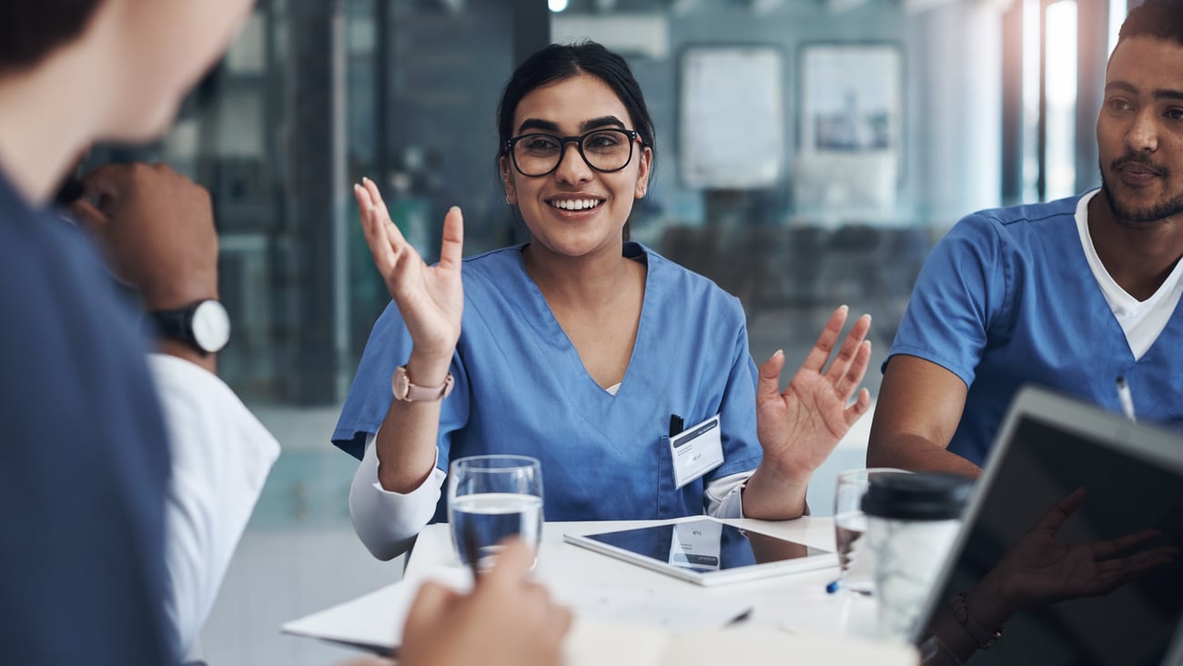 Doctors sitting around at a table in an education setting.