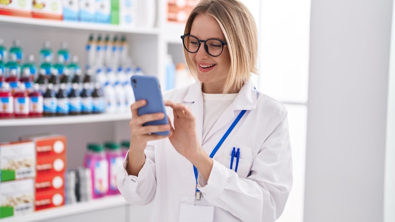 A pharmacist holding a smartphone