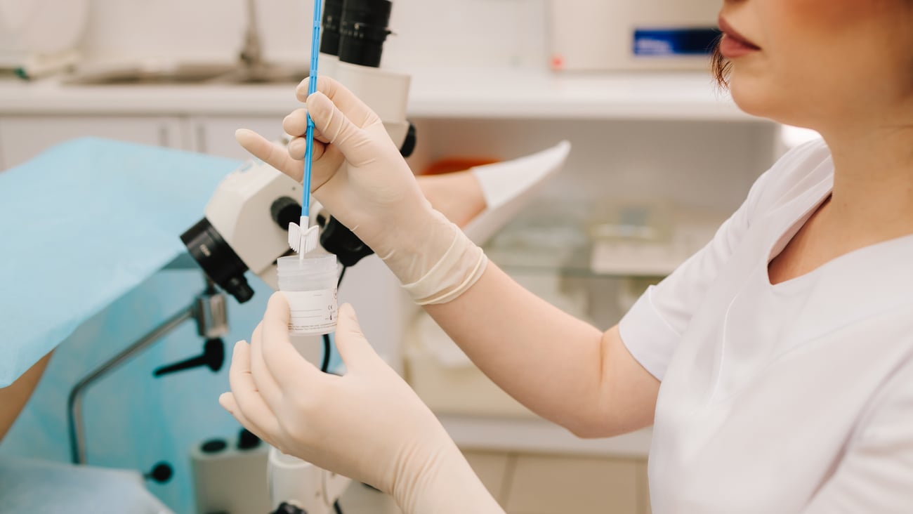 A gynecologist collects a pap smear sample for cervical screening.