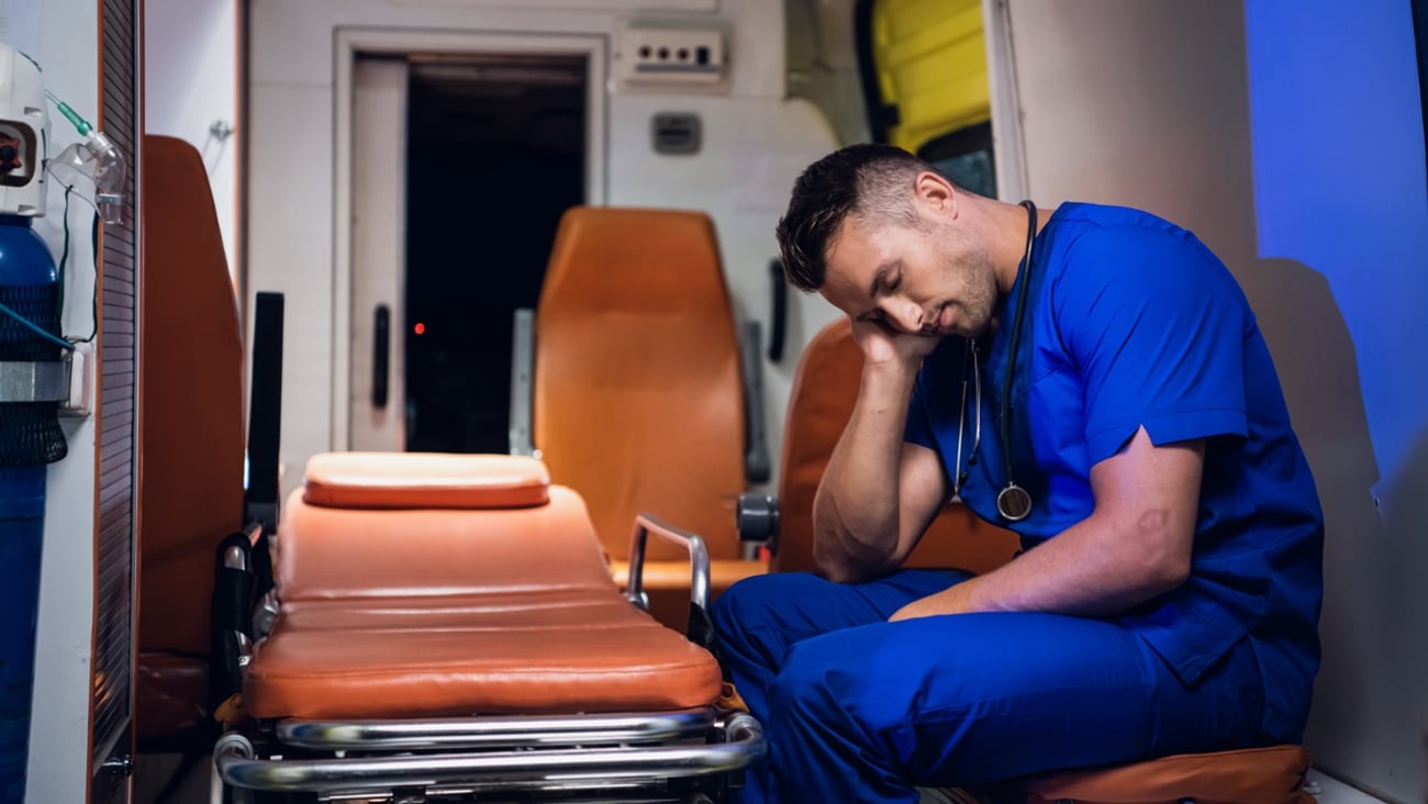 An exhausted EMT napping on the job.