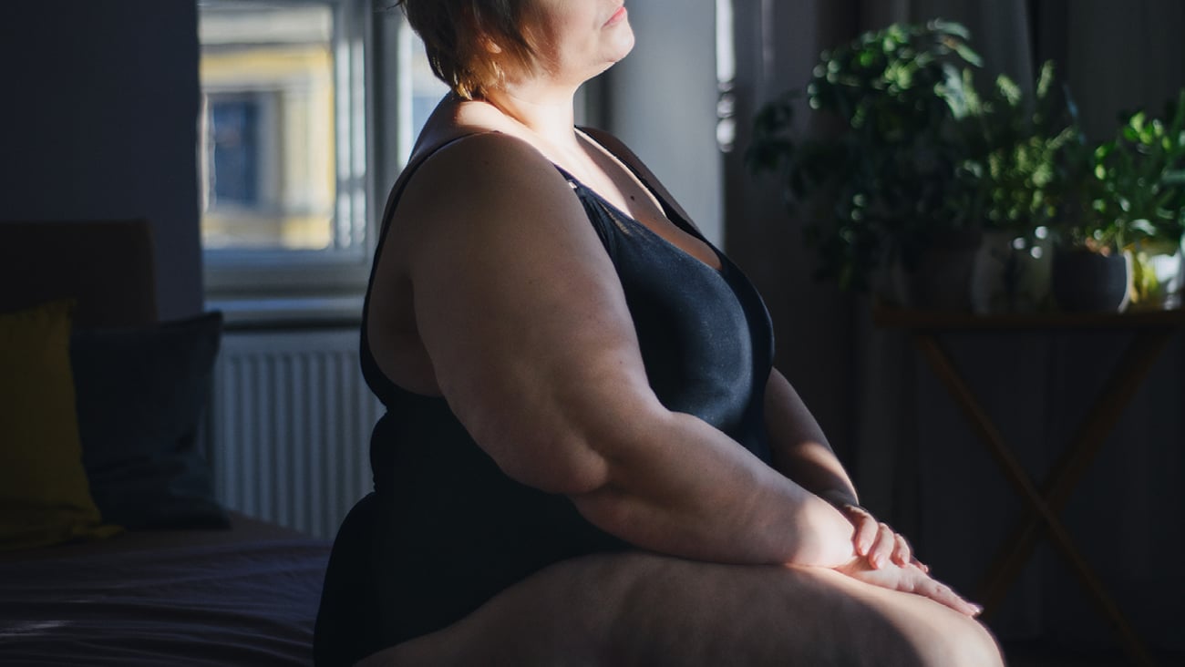 Middle aged woman sitting on her bed