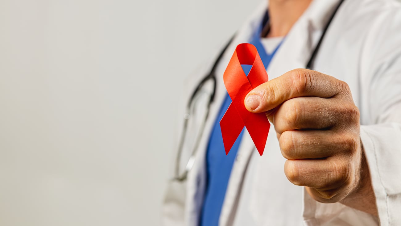 A doctor holding a reds AIDs awareness ribbon