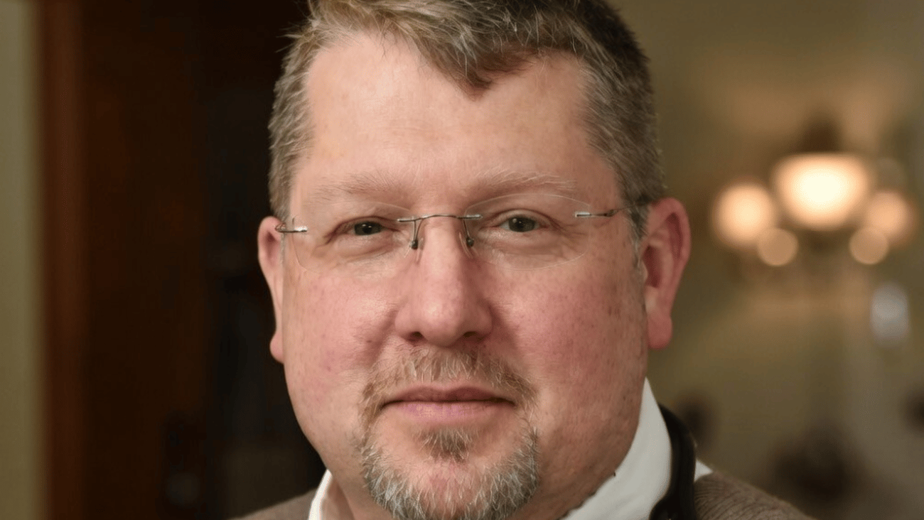 Dr. Darren Cargill, a fair-skinned male doctor with glasses