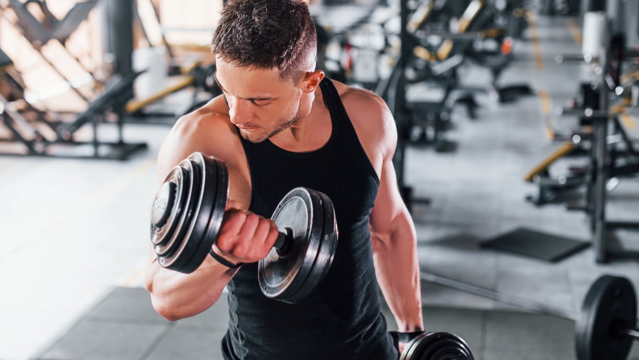 Young man lifting weights in the gym