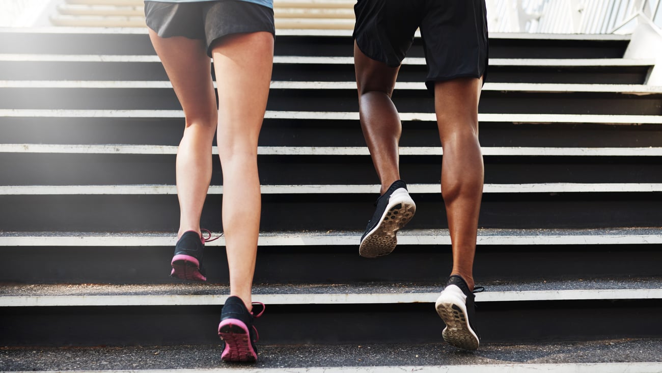 Two people running up stairs together