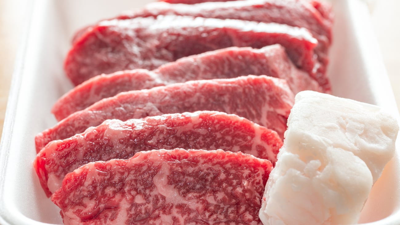 Slices of raw beef with a lump of tallow