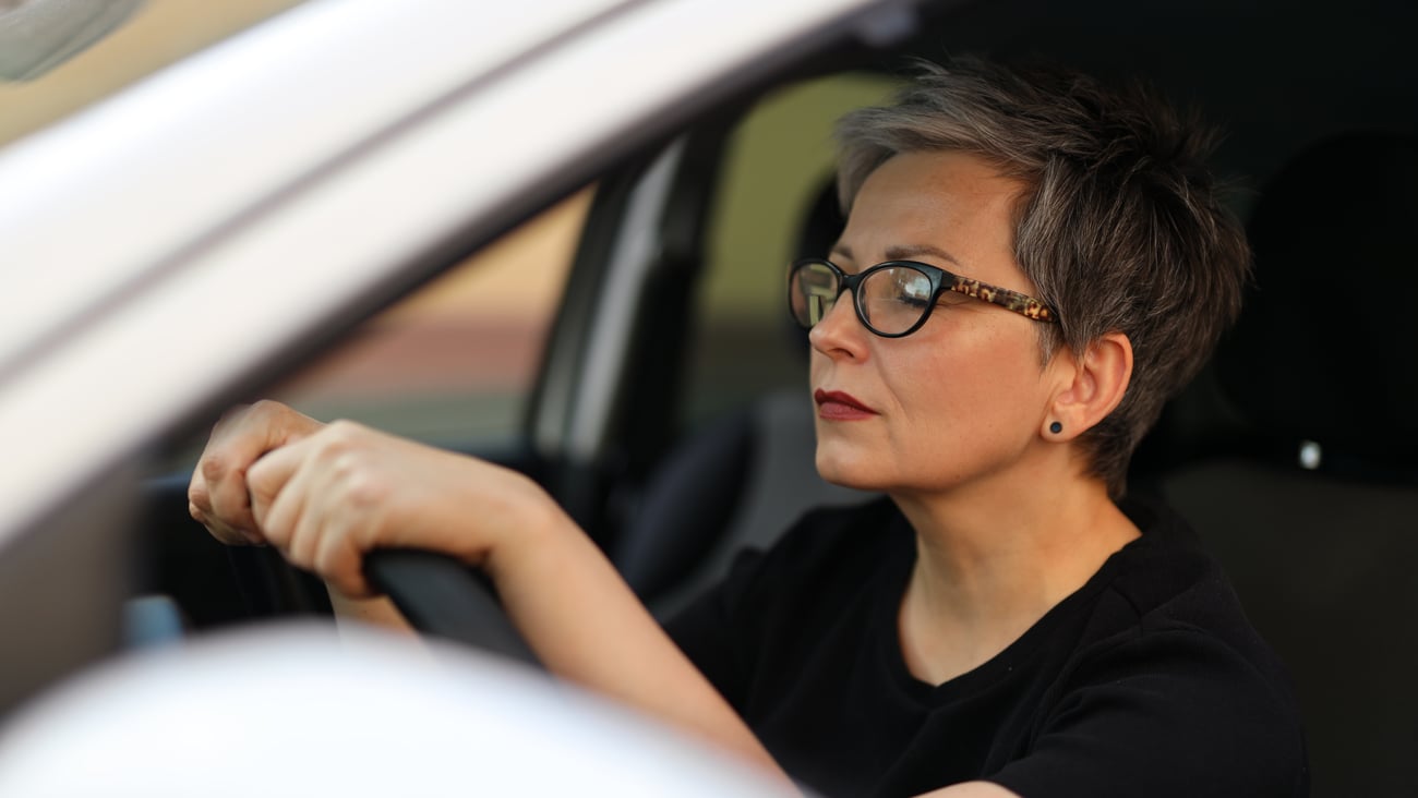 Woman resting her eyes in her car