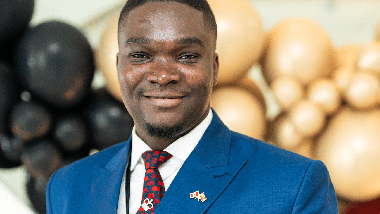 Black man in blue suit with red tie