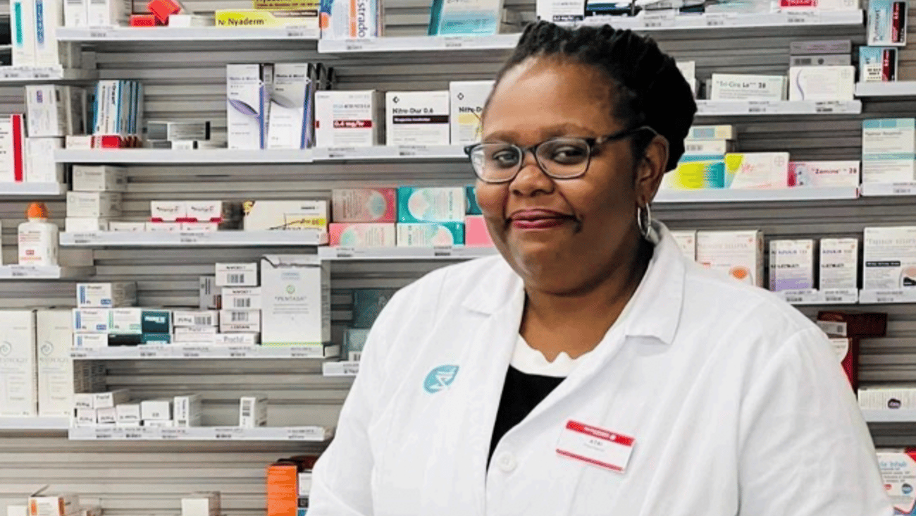 Atai Okokon standing in front of a wall of drugs