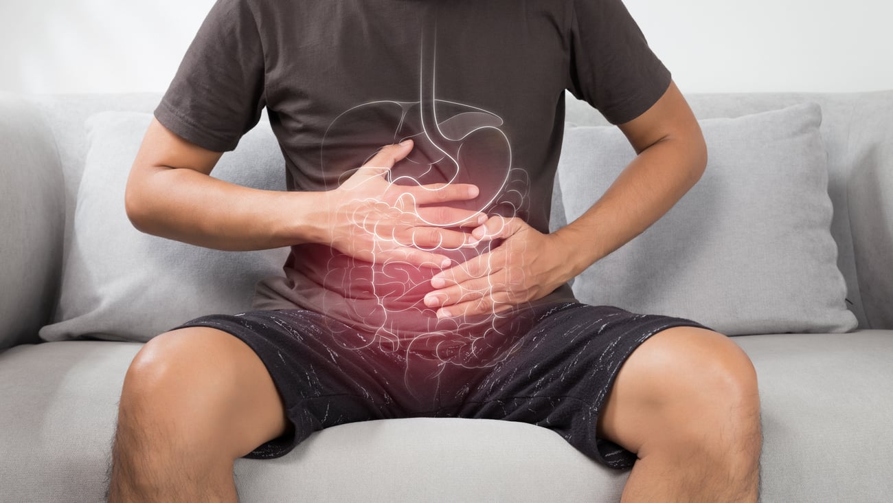 Young man holding stomach in discomfort 