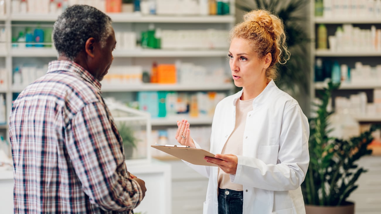 Female pharmacist chatting with older male patient