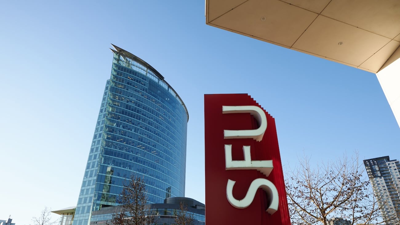 A skyscraper beside a sign that says SFU