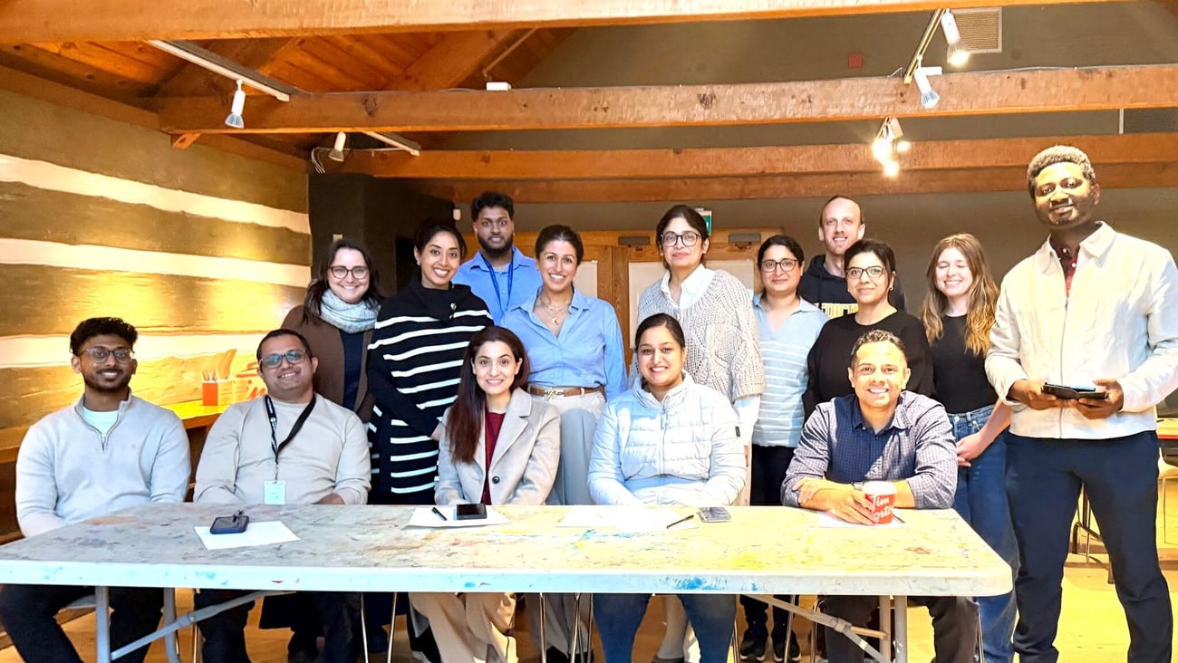 Group of medical residents in professional clothes sitting in a log building.
