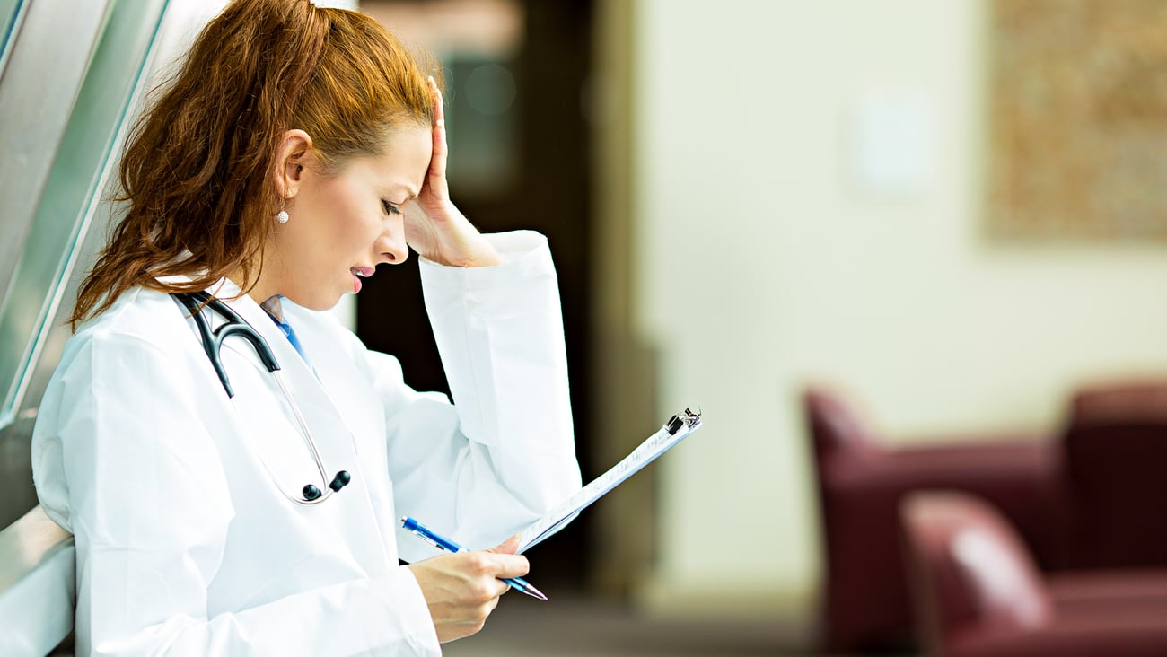 Young woman doctor looking frustrated at a chart