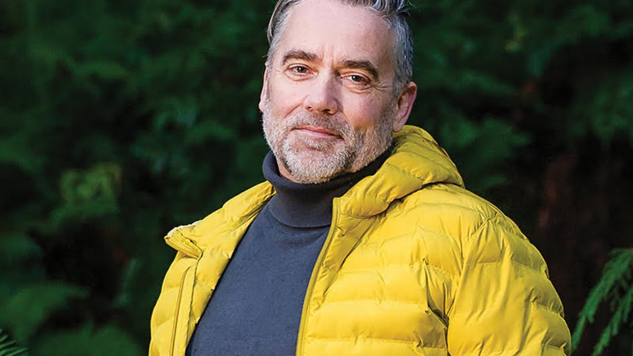Dr. Adam Thompson in a bright yellow jacket in the woods