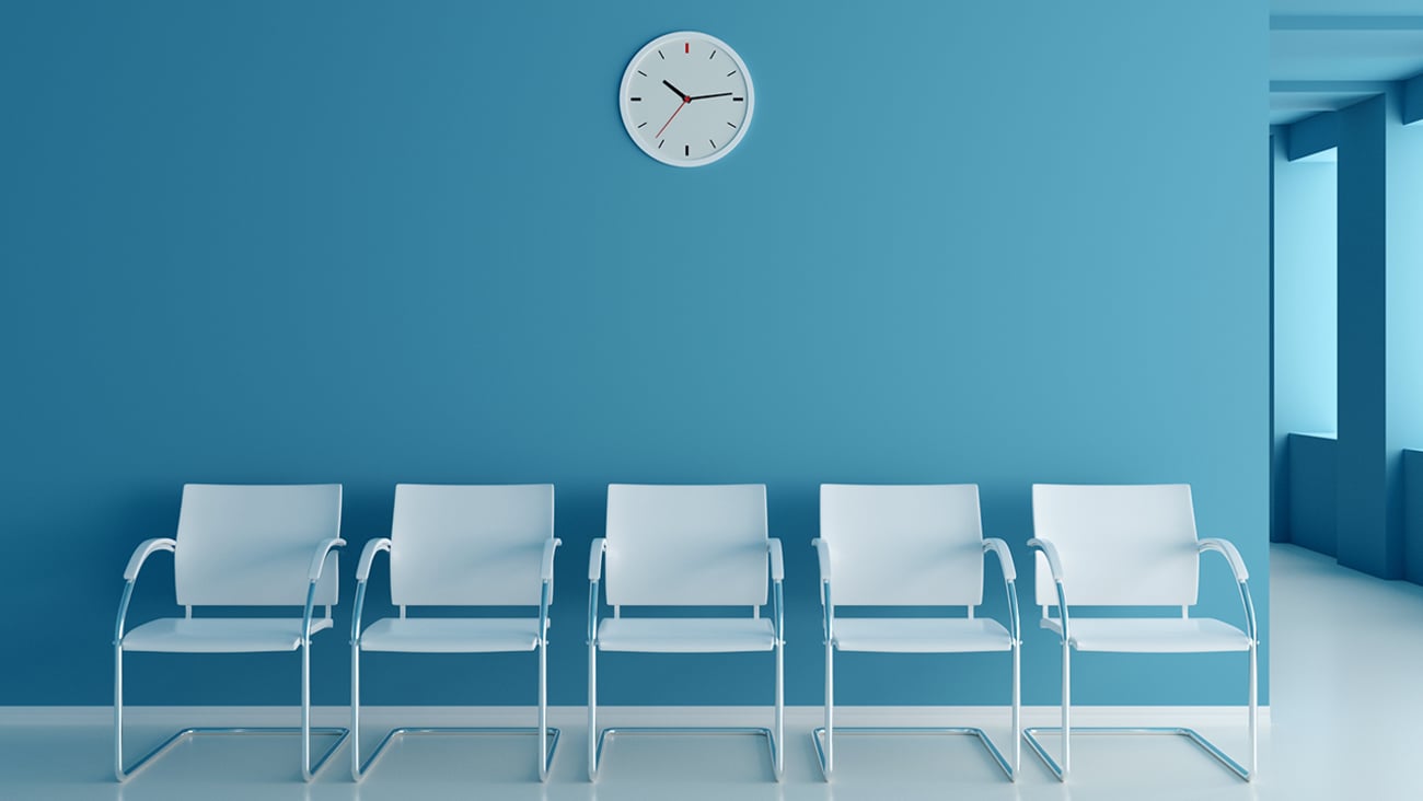 A set of white empty chairs in a clinic waiting room