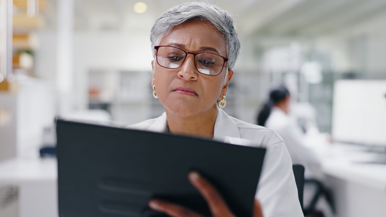 Woman pharmacist reading a chart with a puzzled expression 
