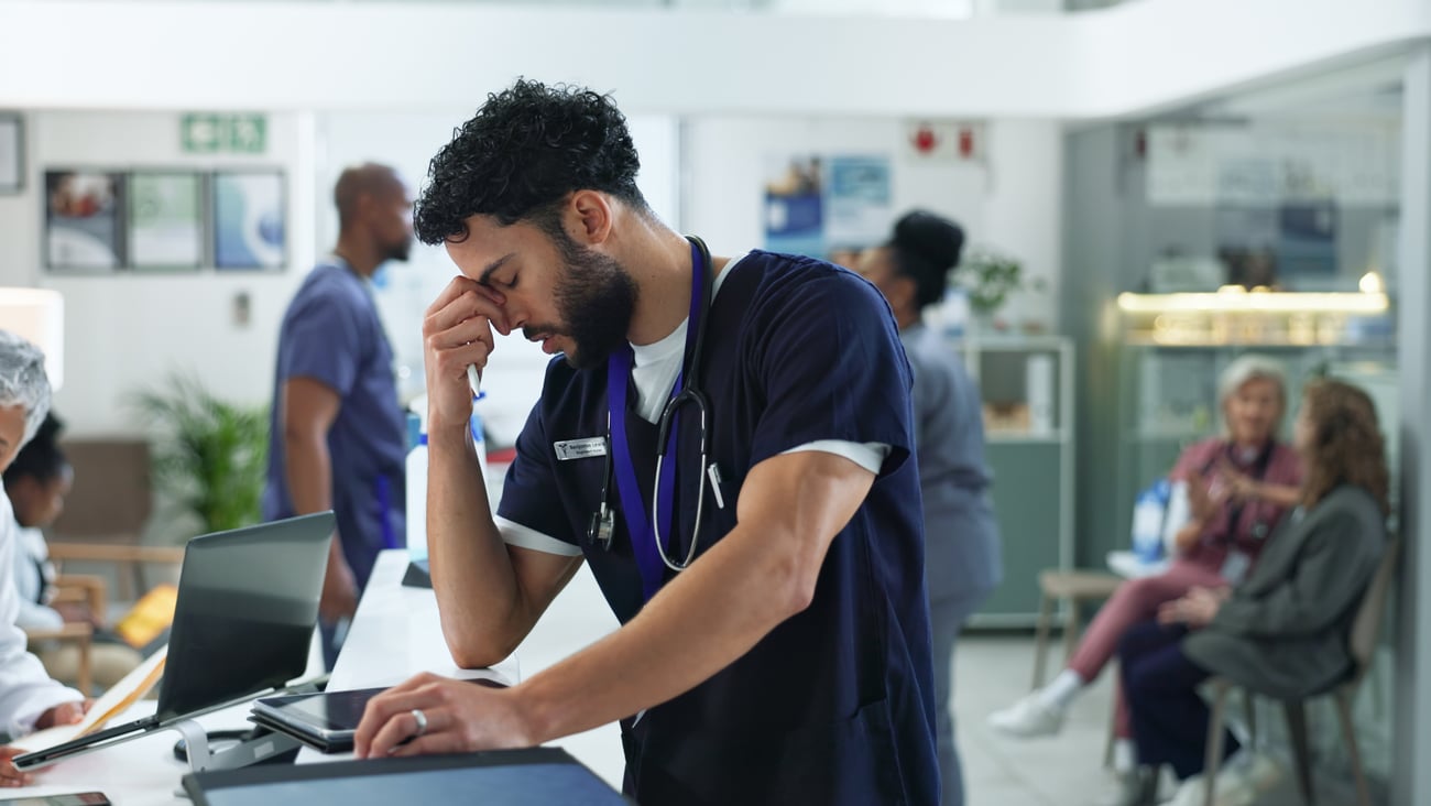 A doctor wearing a stethoscope experiencing burnout.  