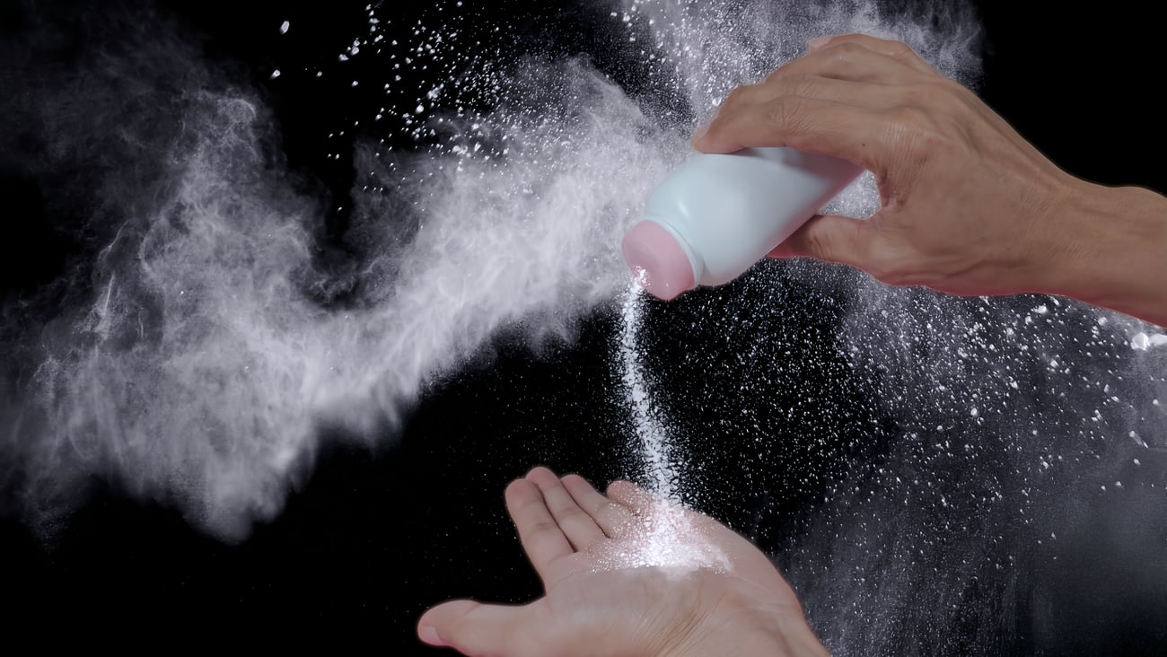 A person pouring baby powder out of a bottle