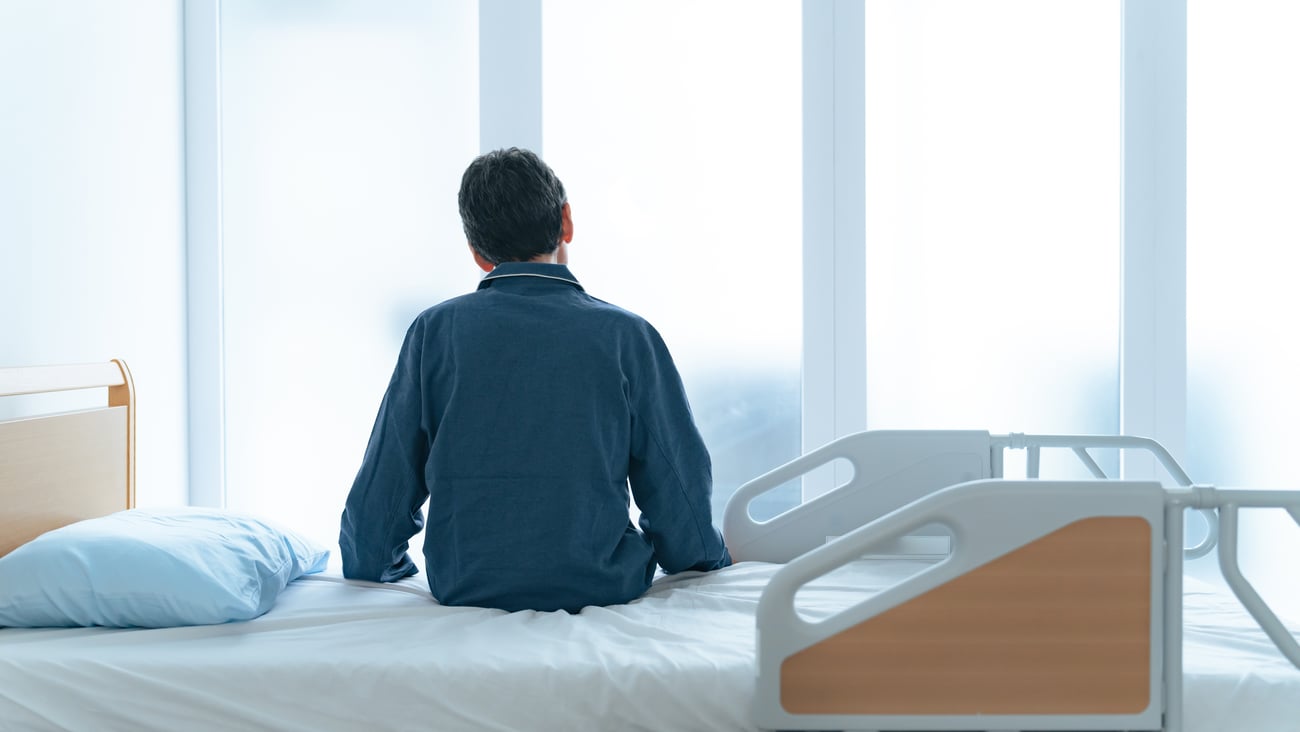 A hospital patient sitting on a bed.