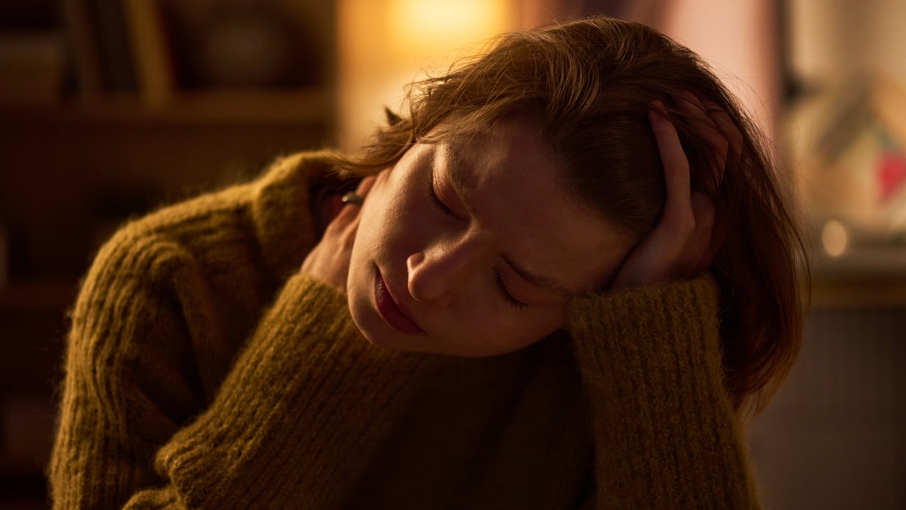 A young woman in pain sitting in the dark