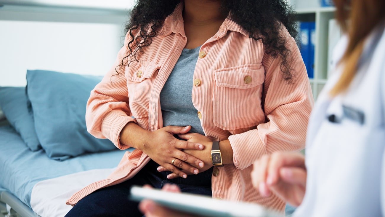 Pain, gynecologist and doctor with woman in hospital for consulting, appointment and endometriosis
