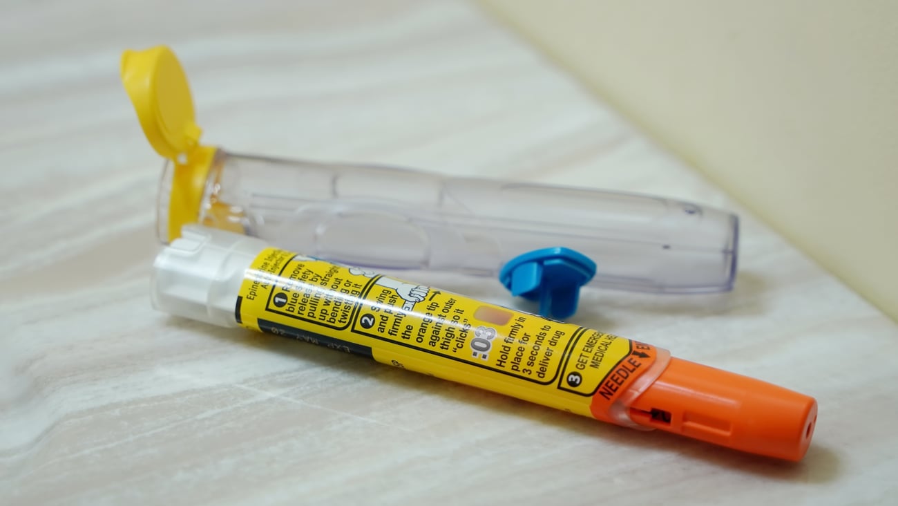 Used Epipen auto injector lying discarded by the side of the sink.