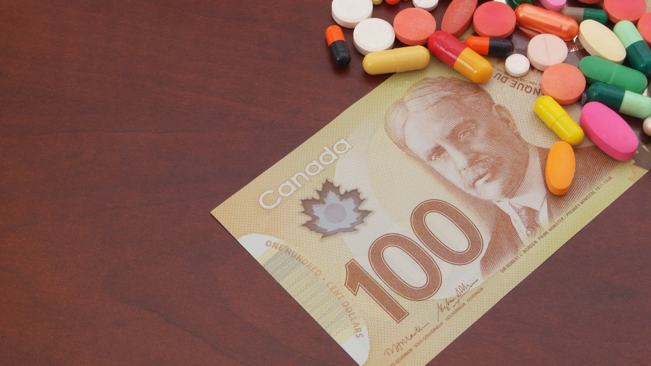 Brightly coloured pills sit on a Canadian 100 dollar bill