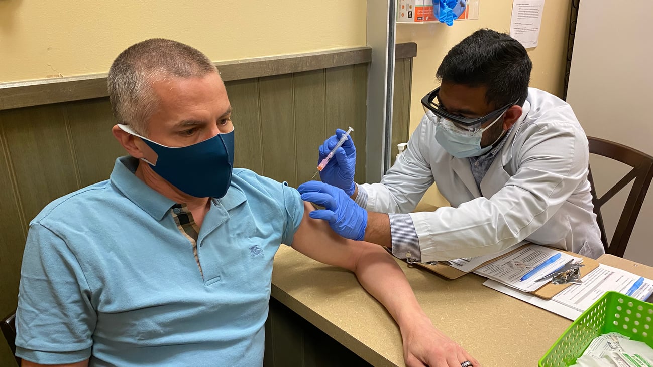 A man gets a COVID-19 vaccine at a pharmacy in Calgary.