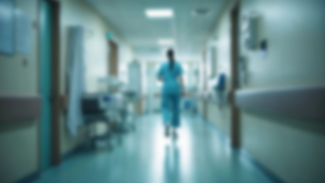 Blurry photo of a female doctor walking down a hospital corridor 