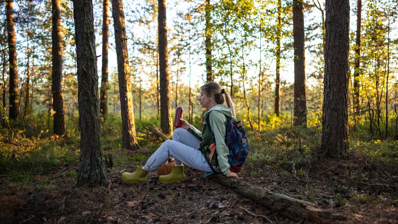 Young woman resting after part of a hike in a wooded area