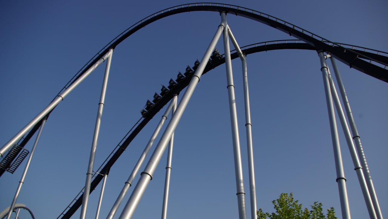 Amusement park attendees ride a roller coaster.