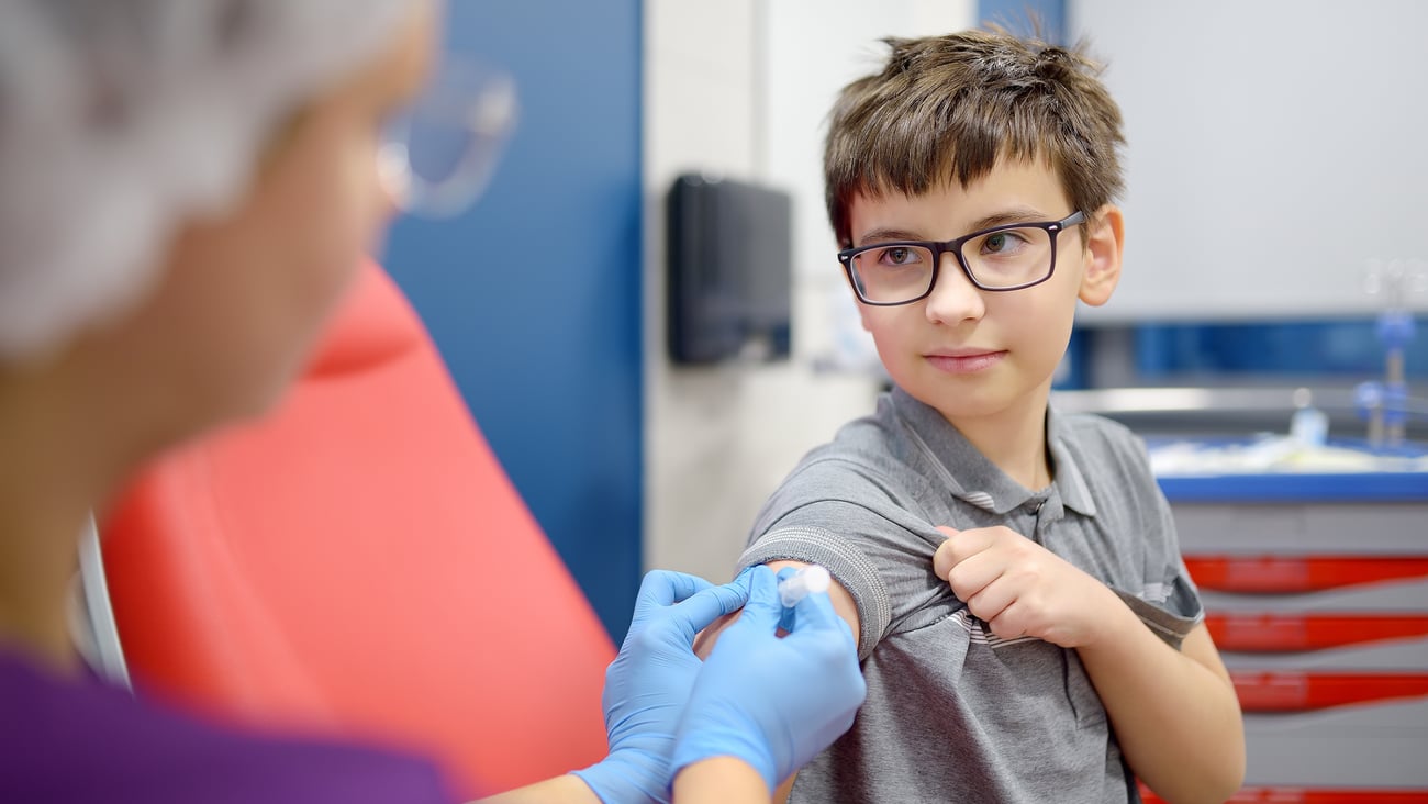 Young boy looking happy about to receive a vaccine